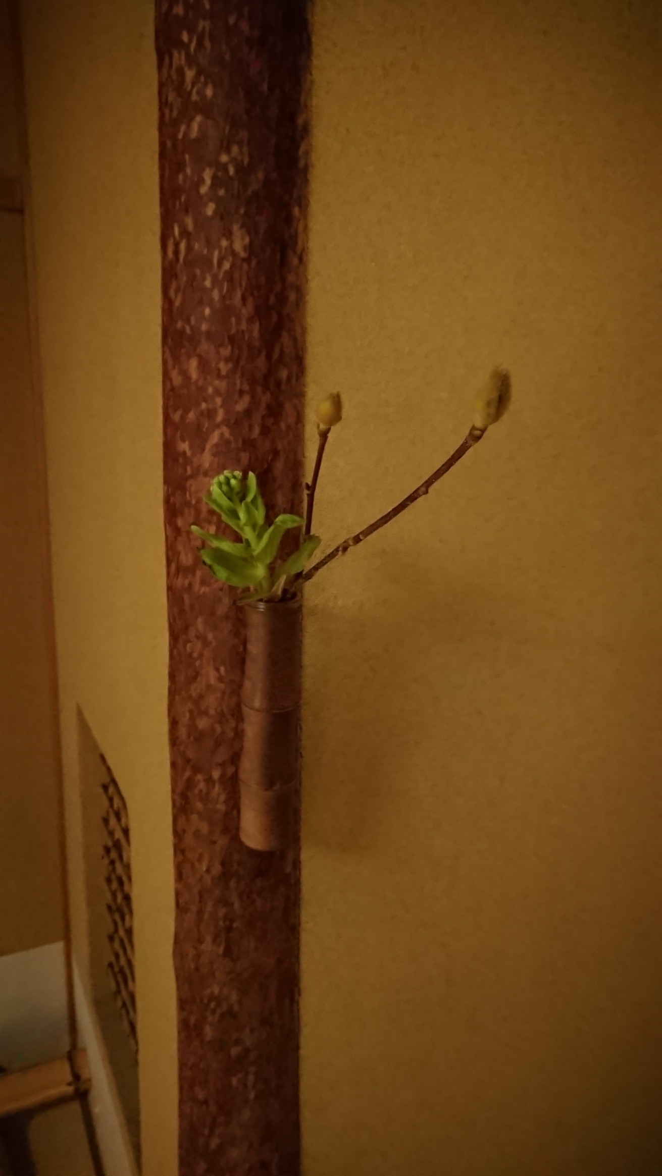 「なかくぎ」に掛かる花入れとその中に活けてある花の写真